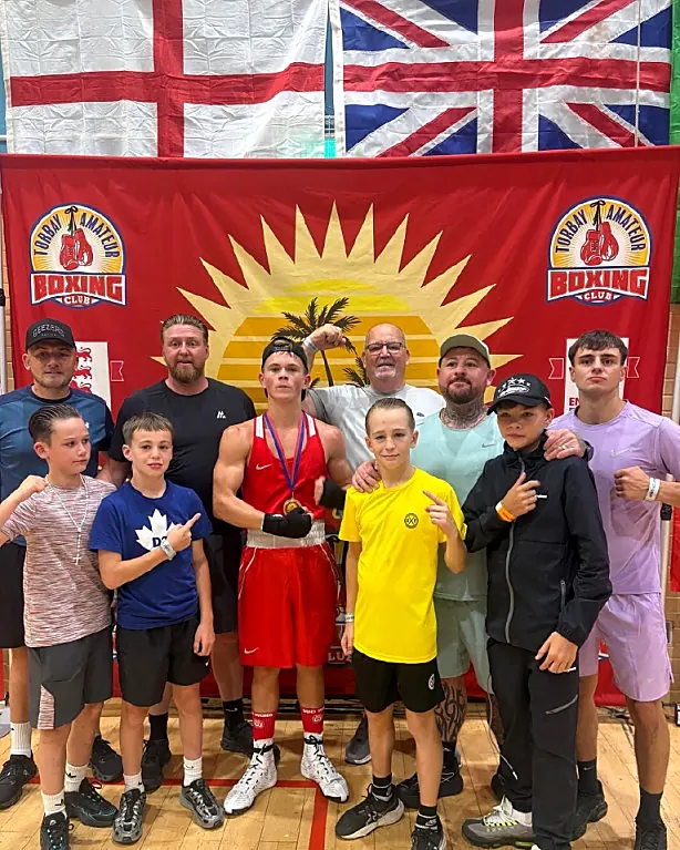 Junior boxers and coaches with a medal at a boxing show
