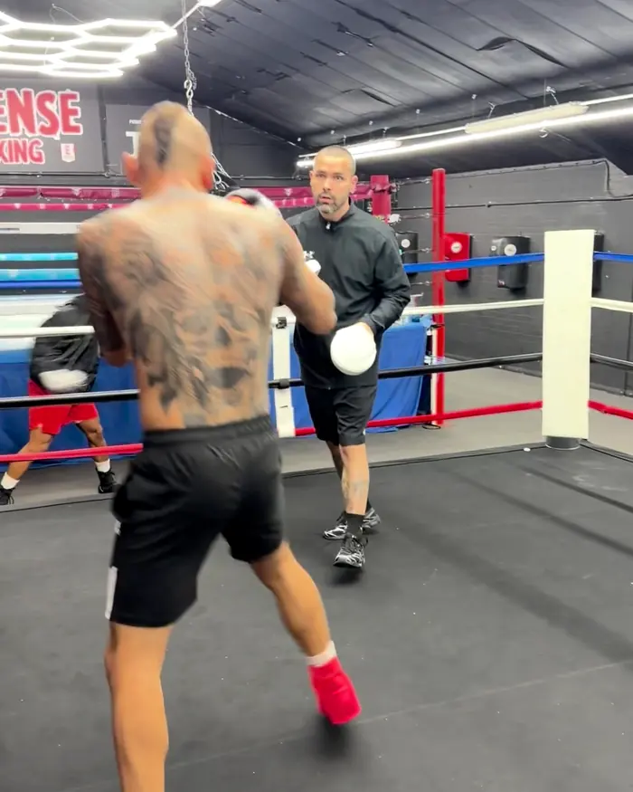 A boxer throws a right hand on the pads with a coach at Intense Boxing, Plymouth